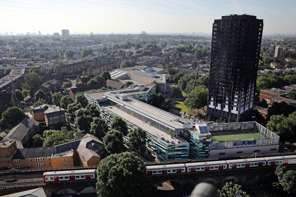 A train drives past Grenfall tower, as it continues to smoulder on June 15, 2017 in London, England.