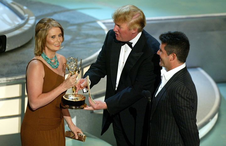 Cynthia Nixon accepts her award for Best Supporting Actress in a Comedy Series for “Sex and the City” with Donald Trump (L) and Simon Cowell on stage during the 56th Annual Primetime Emmy Awards.