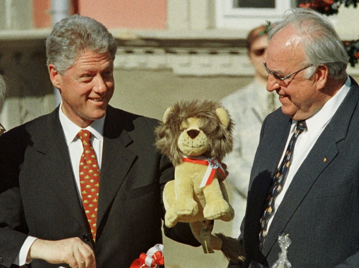 President Bill Clinton (L) displays a toy lion as German Chancellor Helmut Kohl (R) looks on after Clinton received a basket with goods from Thuringia during their visit to the eastern German city of Eisenach, May 14.