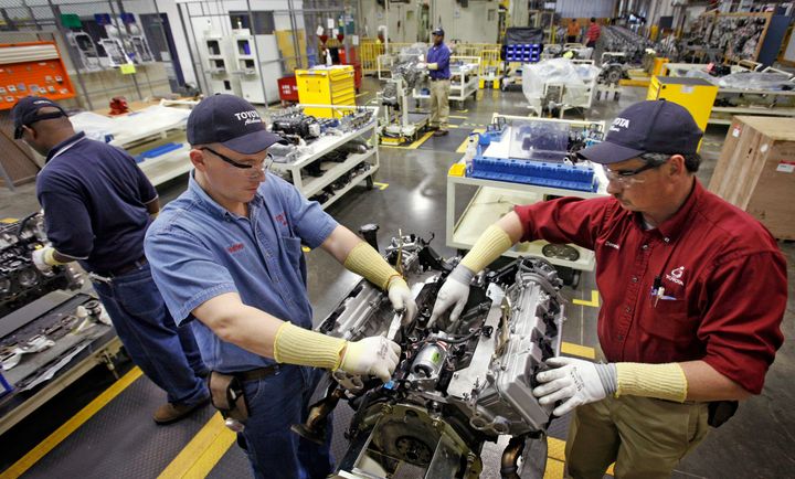 Employees disassemble a motor in the quality control department of the Toyota Motor Manufacturing plant in Huntsville, Alabama, on Feb. 28, 2006.