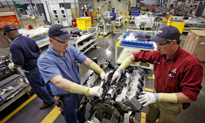 Employees disassemble a motor in the quality control department of the Toyota Motor Manufacturing plant in Huntsville, Alabam