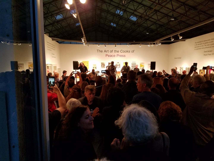 The opening of The Art of the Cooks of Peace Press, June 3,2017, featuring Bob Zaugh in the foreground and the Chambers Brothers onstage.