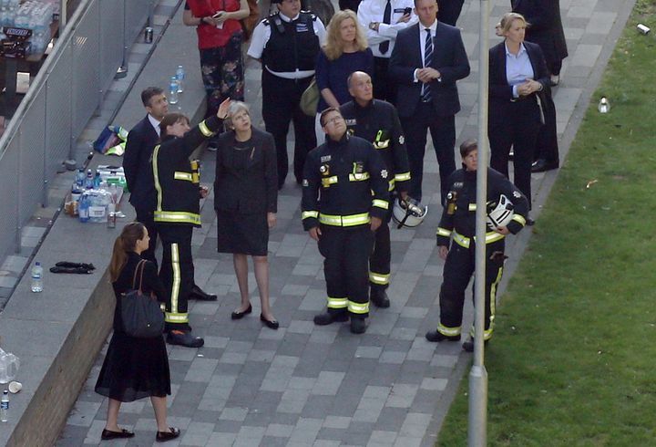 Theresa May had been criticised for keeping away from locals during an initial visit to Grenfell Tower. Pictured here on Thursday meeting fire officials