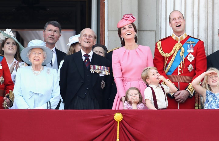 The royal family watching a fly by by a Royal Air Force plane.