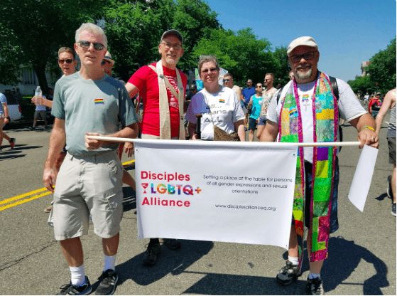 <p><em>Members of Disciples LGBTQ+ Alliance movement (formerly known as GLAD) Christian Church minister Rev. Allen Harris (second from left) and First Christian Church assistant pastor Dan Adolphson (on the right) were among faith leaders who marched in Washington D.C. last weekend.</em></p>