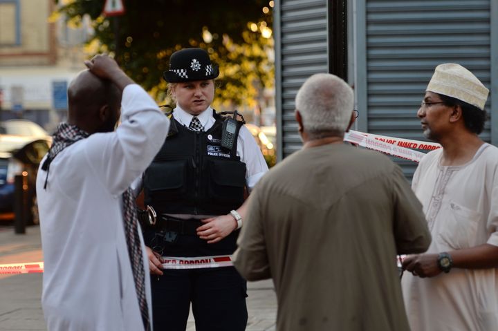 A police officer talks to local people at Finsbury Park in north London, where one man has died, eight people taken to hospital and a person arrested after a van struck pedestrians.