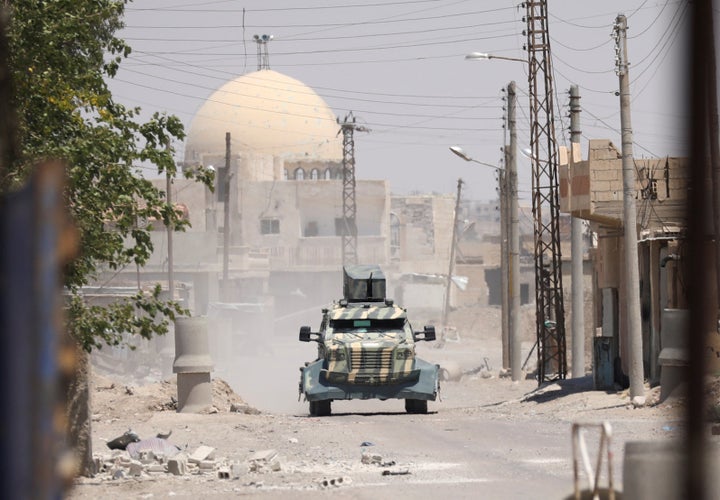 A military vehicle operated by the U.S.-backed . Syrian Democratic Forces rumbles through the Raqqa area on Sunday. 