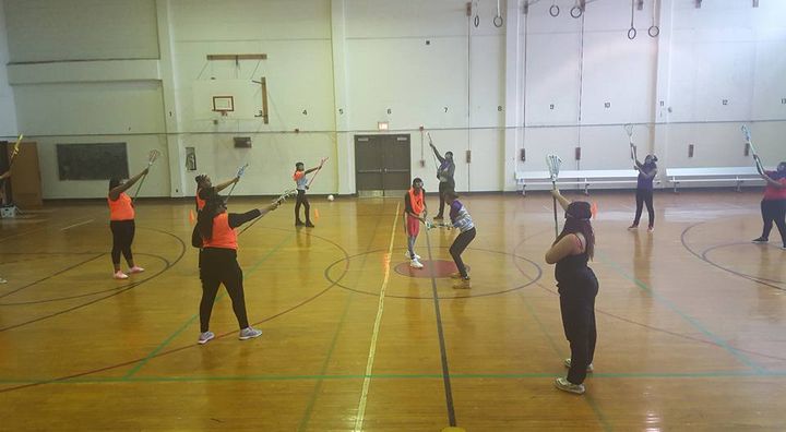 During one of their first practices, Strawberry Mansion High School girl’s lacrosse team participants learn the game in the historic school’s gymnasium. Three of those pictured are headed to play lacrosse in college this fall.