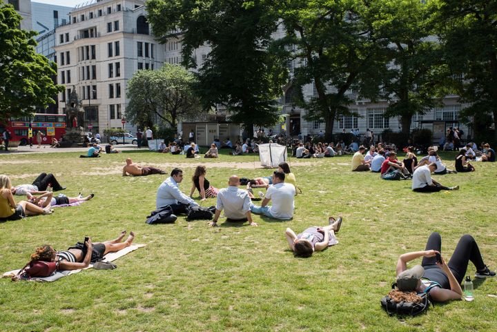 Workers relax in the sun during lunch time in London's Finsbury Square
