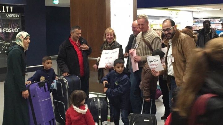 Members of a community sponsorship group in Salford welcome a family of Syrian refugees at Manchester airport