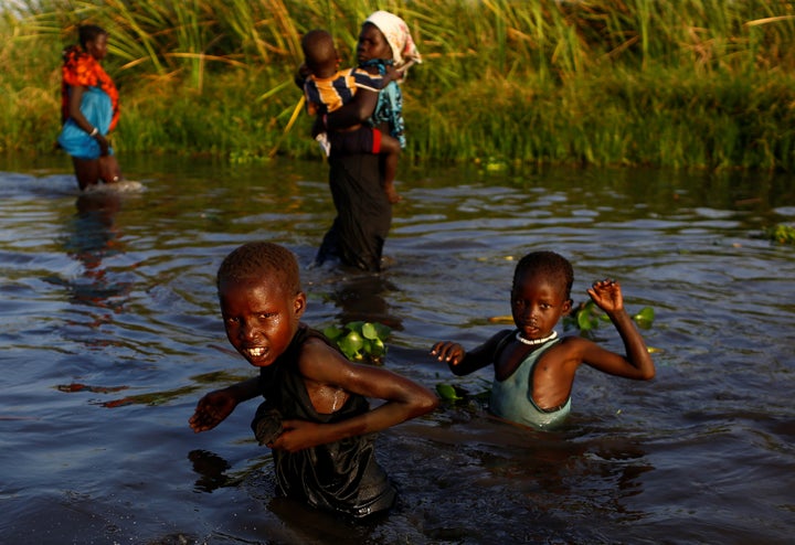 Children cross a body of water to reach a food registration area in South Sudan on Feb. 25, 2017.