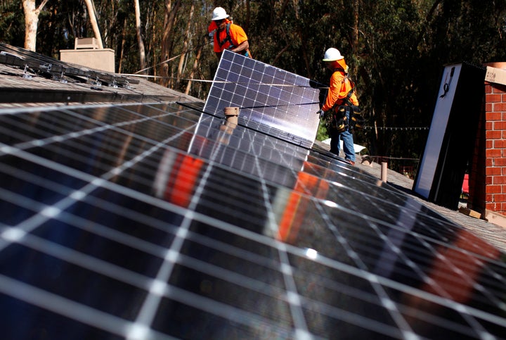 Solar installers from Baker Electric place solar panels on the roof of a residential home in Scripps Ranch, San Diego, Califo