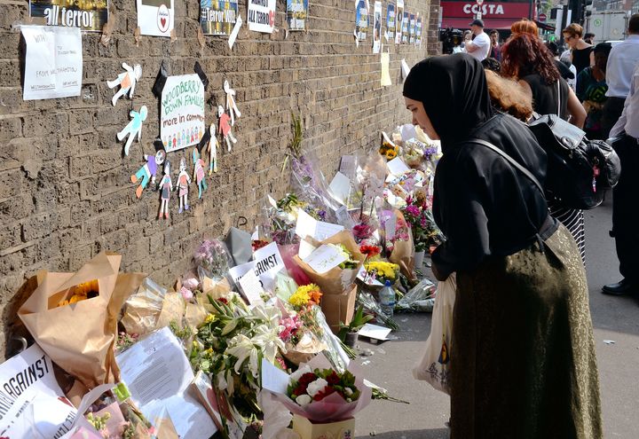A woman leaves a floral tribute on Seven Sister Road close to Finsbury Park Mosque in north London