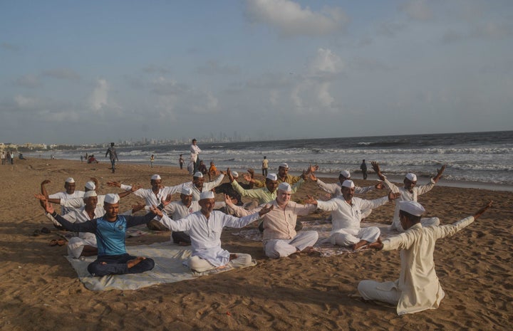 On the eve of World Yoga Day Mumbai's Dabawala celebrated by doing yoga exercises at Versova beach. 