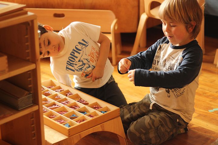 Students at Wildflower Montessori in Cambridge, Massachusetts, help each other practice spelling with wooden cursive letters.