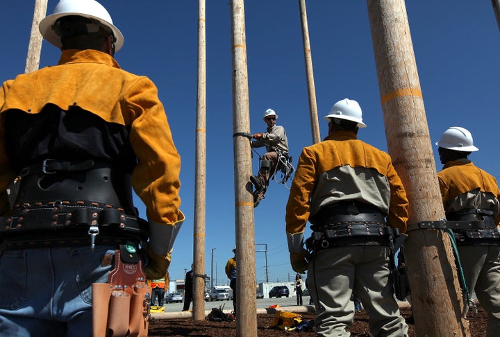 Students watch a Pacific Gas and Electric instructor navigate a utility pole during a training course for the utility industry in Oakland, California. June 8, 2012.