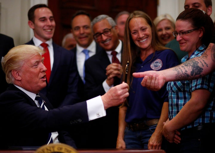 Trump hands a pen to Charles Robel after delivering remarks on "Apprenticeship and Workforce of Tomorrow" initiatives at the White House. June 15.