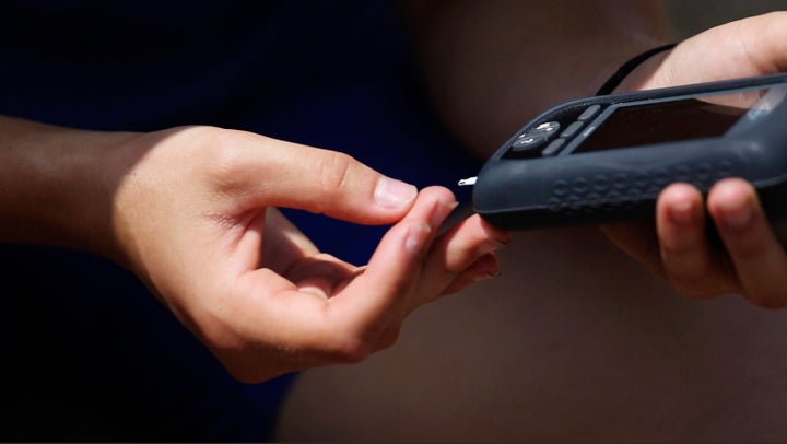 A woman checks her blood sugar level.