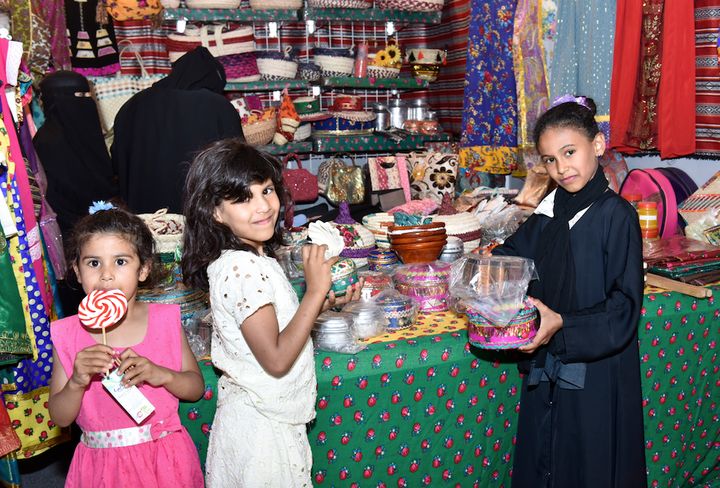 Young girls at the camel festival heritage market, a souk with over 100 booths selling camel equipment, traditional, foods, tapestries, handicrafts, spices and coffee, traditional perfumes, games, tent accessories, antiques, elaborate decorations, camel accessories.