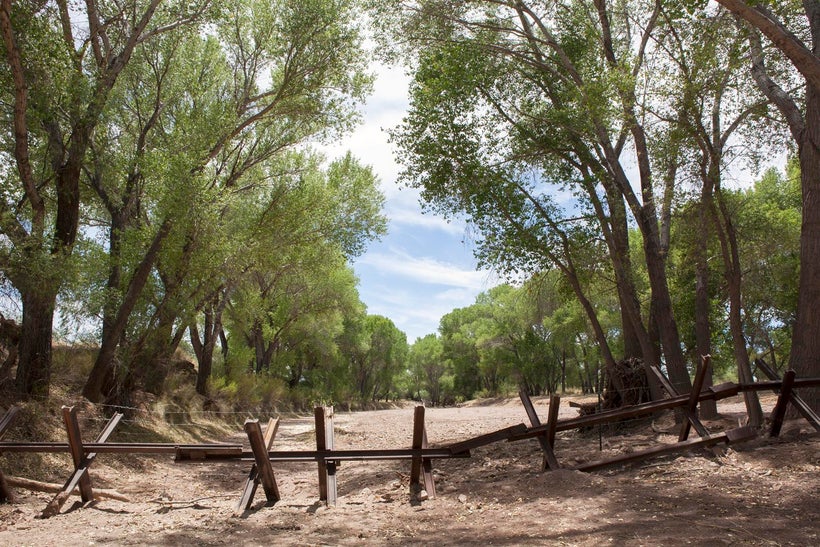 The San Pedro runs dry right before summer rains at the border with Mexico. Vehicle barriers in the dry pre-monsoonal San Ped
