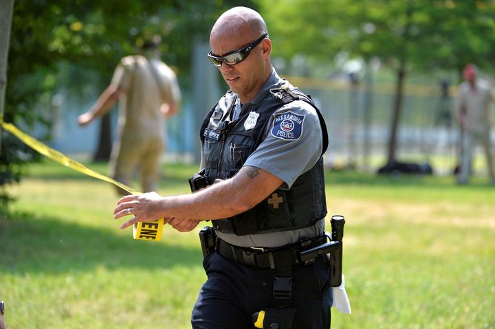Police put up tape to clear journalists from the outfield area of a baseball field where shots were fired during a congressional baseball practice, wounding House Majority Whip Steve Scalise (R-La.), in Alexandria, Virginia, on June 14.