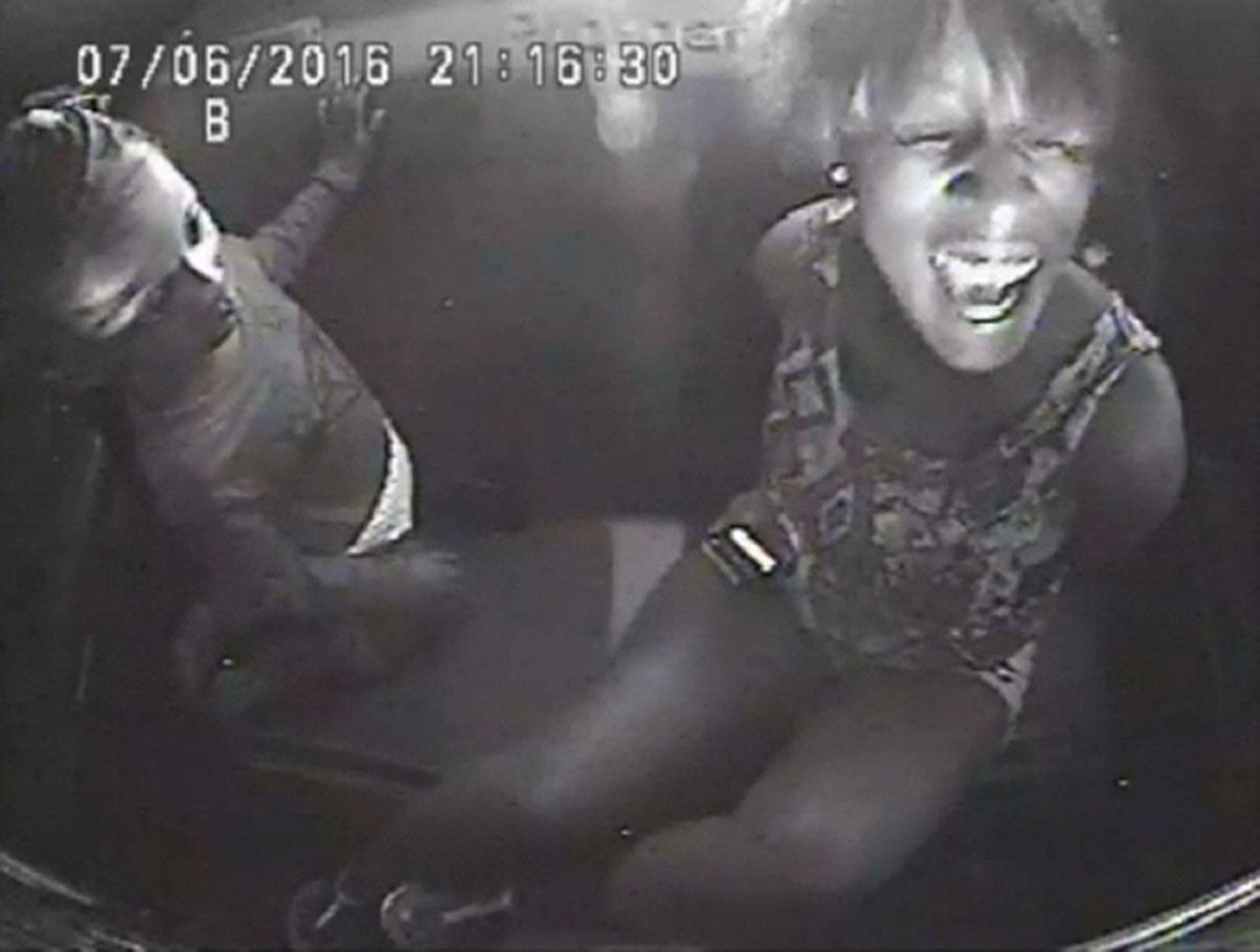A still image from police video shows Diamond Reynolds crying beside her daughter while handcuffed in the back seat of a police patrol vehicle, after her boyfriend, Philando Castile, was fatally shot.