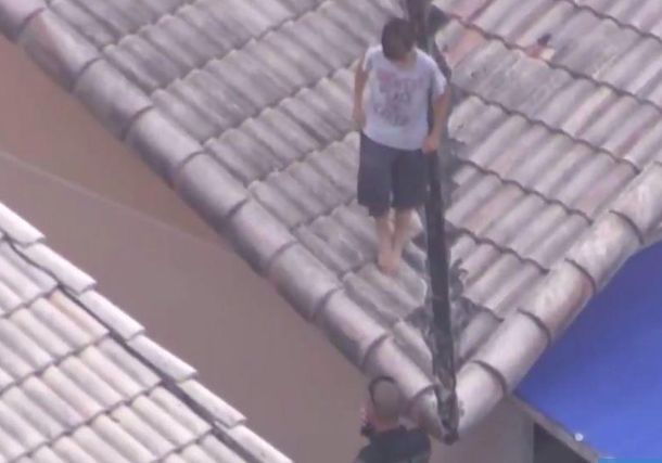 Police officers helped the boy down from the roof 