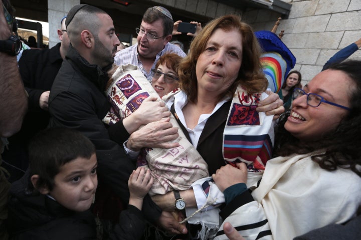 Orthodox Jewish men try to prevent Anat Hoffman (C), the founder and President of the liberal Jewish religious group Women of the Wall, and members of the group, from entering the women's section of the Western Wall while carrying a Torah scroll, in the Old city of Jerusalem on November 2, 2016, during a protest by the group demanding equal prayer rights at the site.