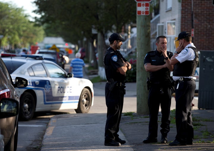 Police investigators talk outside the Montreal home of Amor Ftouhi, June 21, 2017. Ftouhi has been identified as a suspect in the stabbing of a police officer at a small airport in Flint, Michigan.