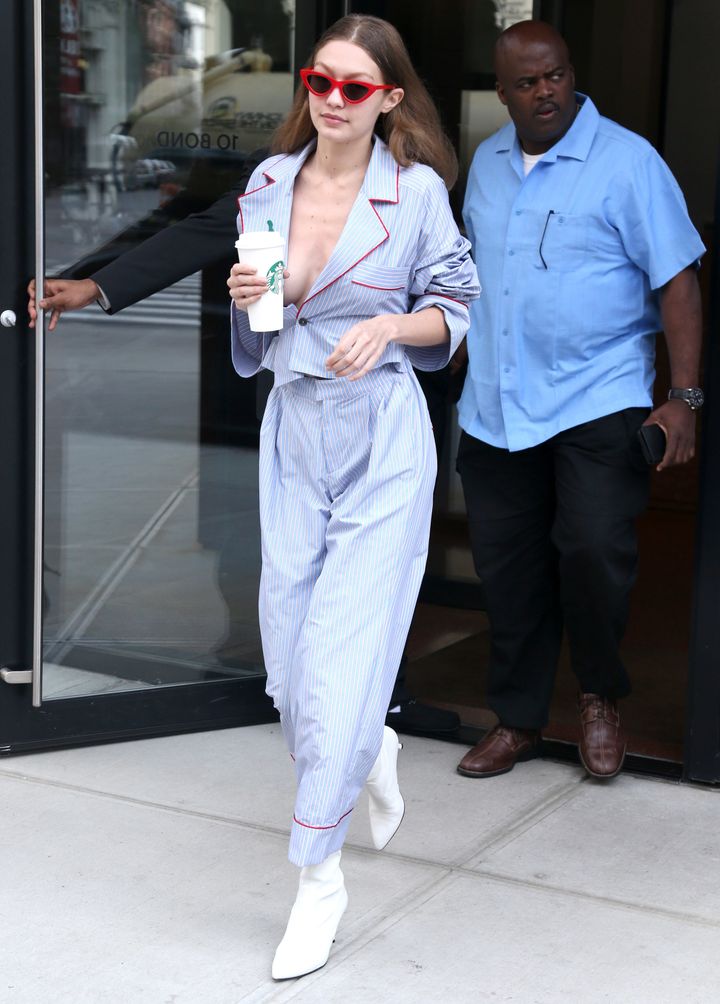 Hadid accessorized with red sunglasses and Starbucks.