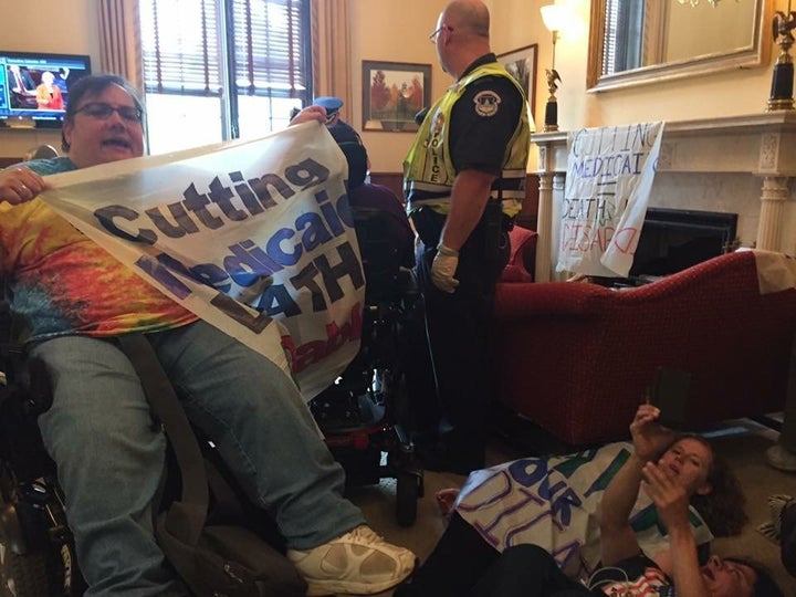 Susan Stahl in McConnell's office shortly before she was arrested. Her banner reads, "Cutting Medicaid = Death 4 Disabled."