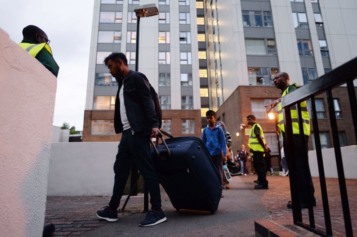 Residents leave the Taplow tower block on the Chalcots Estate