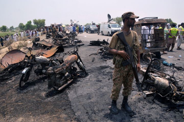 A soldier stands guard amid burnt out cars and motorcycles at the scene of an oil tanker explosion in Bahawalpur, Pakistan June 25, 2017. (REUTERS/Stringer)