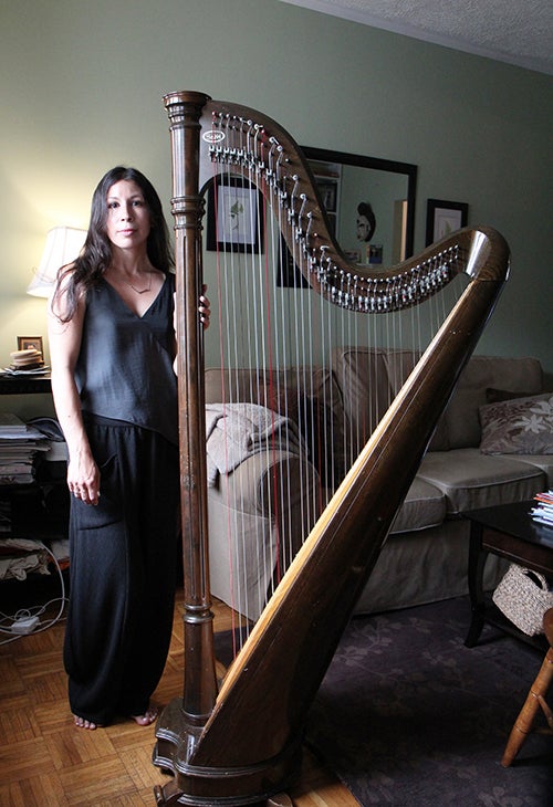 <p><strong>The 50-pound lever harp towers over Tracey.</strong></p>