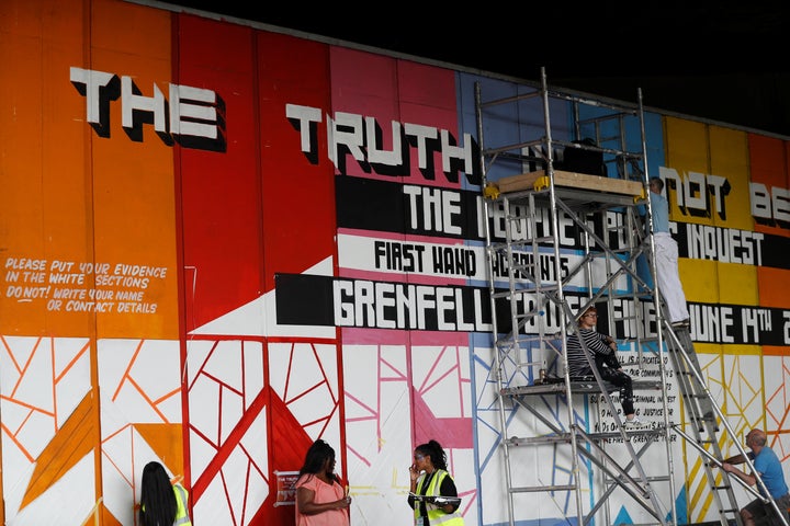 Volunteers work on a mural on which people will be encouraged to write accounts of their experiences in connection with the G
