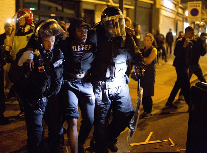 A man is carried by riot police following clashes