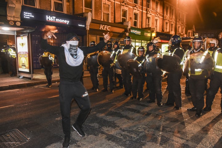 A demonstrator stands in front of riot police