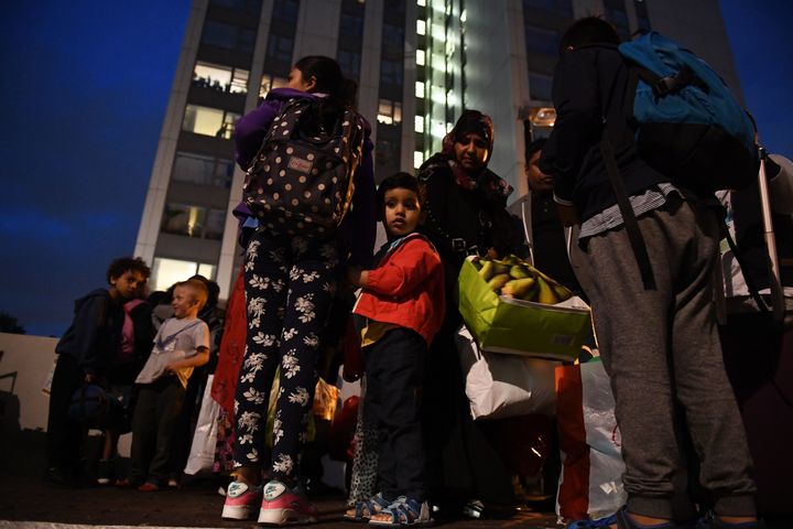 People leave a high rise on the Chalcots Estate on Friday evening, after Camden Council ordered the evacuation of five tower blocks