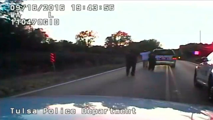 A still image captured from a dashcam video from Tulsa Police Department shows Terence Crutcher with his hands in the air fol