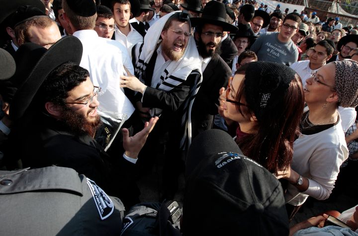 Ultra-Orthodox Jewish men shout at Jewish female activists, members of the Women of the Wall group, during a monthly prayer session at the Western Wall.