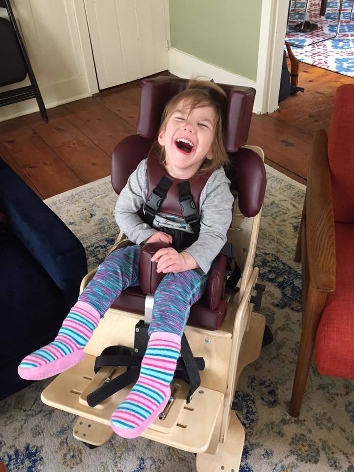 Lucia smiling in her new activity chair.