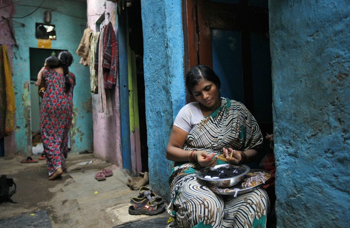  Shobha Vakade, here in 2010, used her US$400 loan to start her own business, strings beads into necklaces outside her house in a Mumbai slum. 