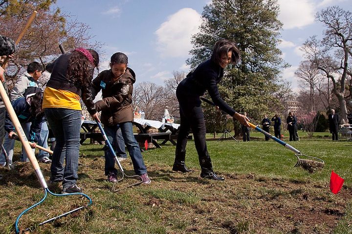 Former First Lady Michelle Obama working with kids from Washington's Bancroft Elementary School to break ground for a White House garden. 