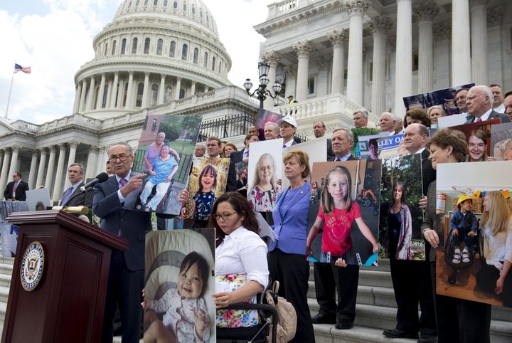 Senate Democrats hold photos of people who would lose their health insurance coverage under the Senate Republicans' health care bill on June 27, 2017. 