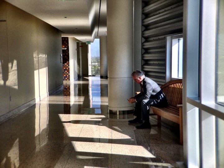 Former Arizona Superintendent of Schools John Huppenthal checks his phone in the federal courthouse in Tucson on June 26, 2017.