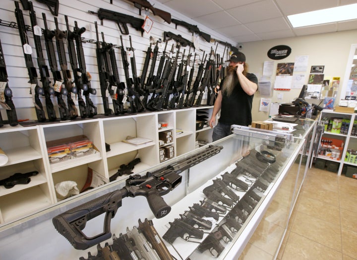 An AR-15 sits on a display case as Willy Ludlow, owner of the "Ready Gunner" gun store, talks on the phone in Provo, Utah, U.S., June 21, 2016.