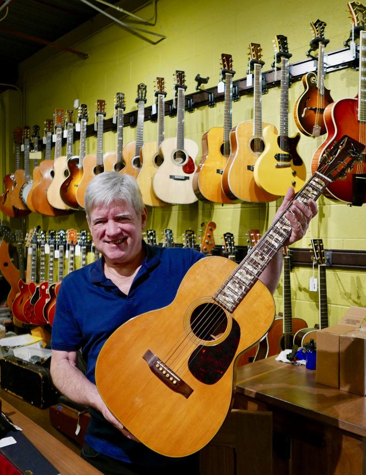 <p><strong>Walter Carter with a guitar that once belonged to Merle Haggard. It can be yours for a six-figure price.</strong></p>