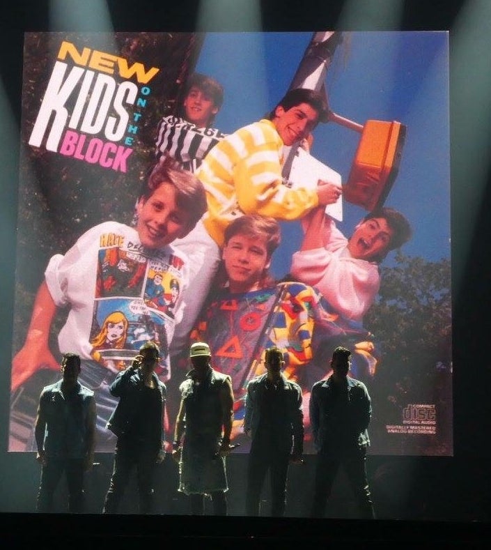 The New Kids stand next to the album cover of their 1986 debut album