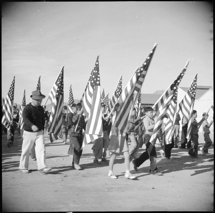 Japanese American schoolchildren march in a parade at the War Relocation Center on the Gila River Indian Reservation in Arizona during World War 2. In total, over 60,000 American children of Japanese descent were incarcerated during the war.