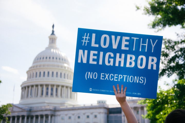 A protestor holds a sign in front of the Capitol building.